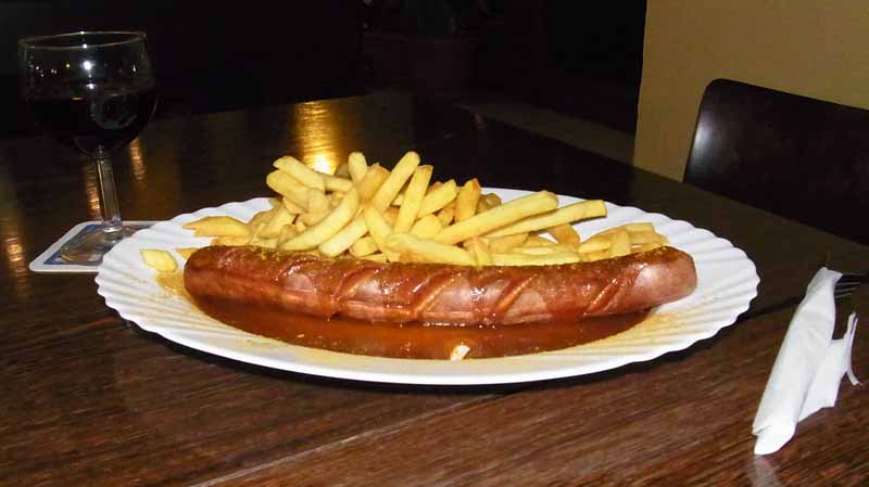 Currywurst mit Pommes und Rotwein